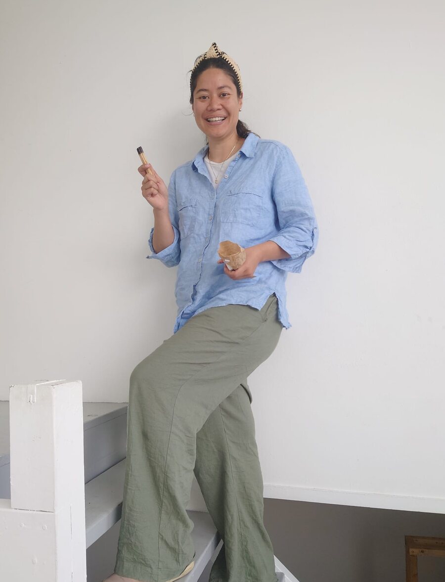 Josy Kang in a light blue shirt on white stairs